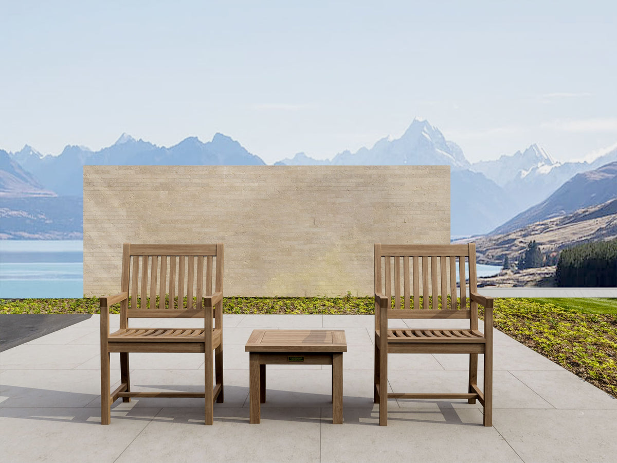 Two wooden chairs with a small table on a patio with mountainous landscape in the background