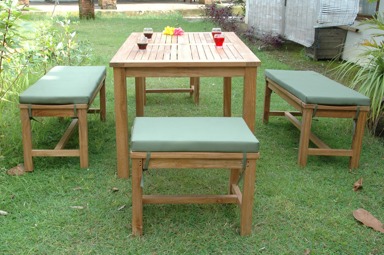 Wooden outdoor table with four matching stools on a grassy area