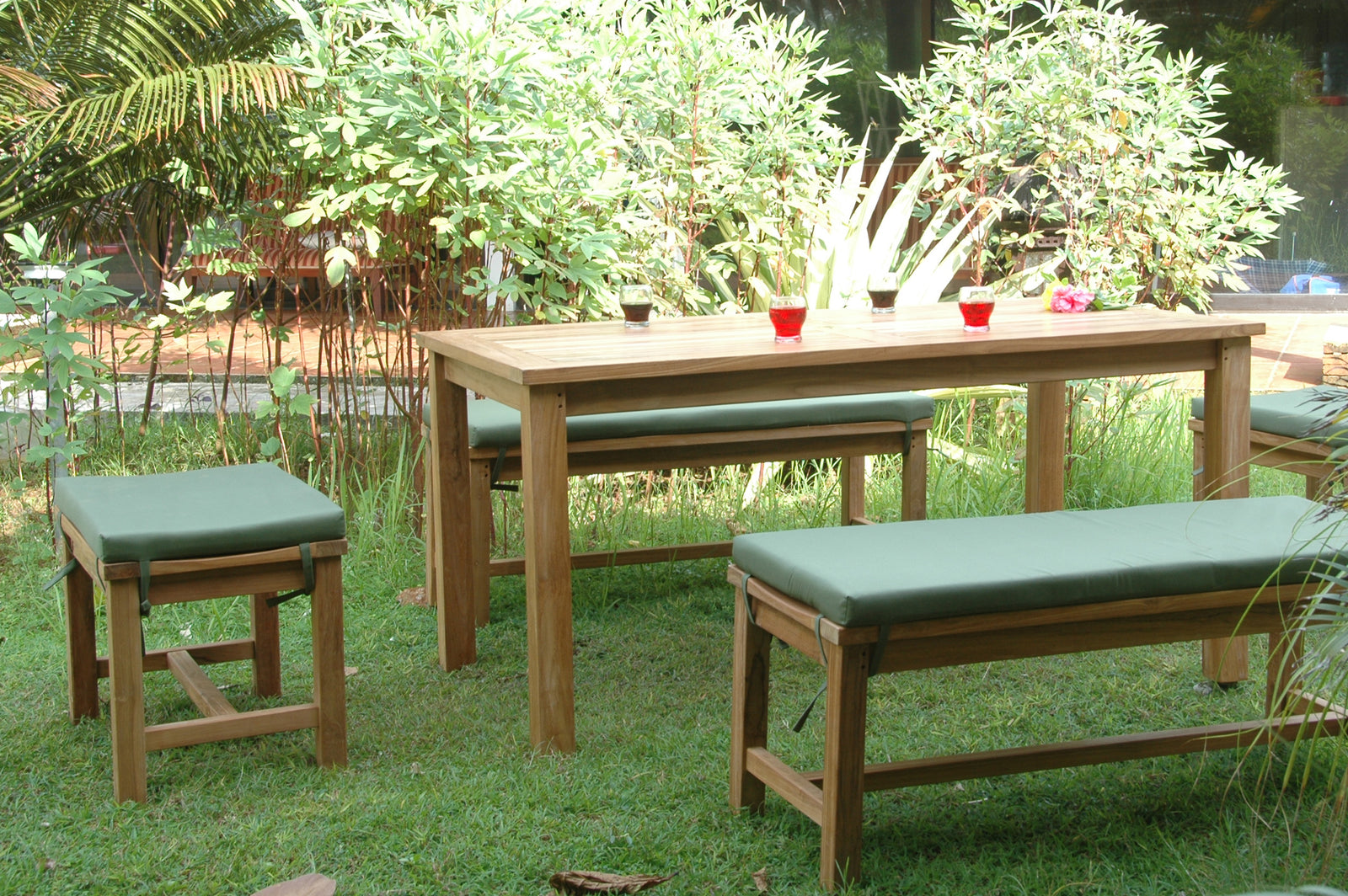 Wooden outdoor furniture set with benches and a table in a garden setting.