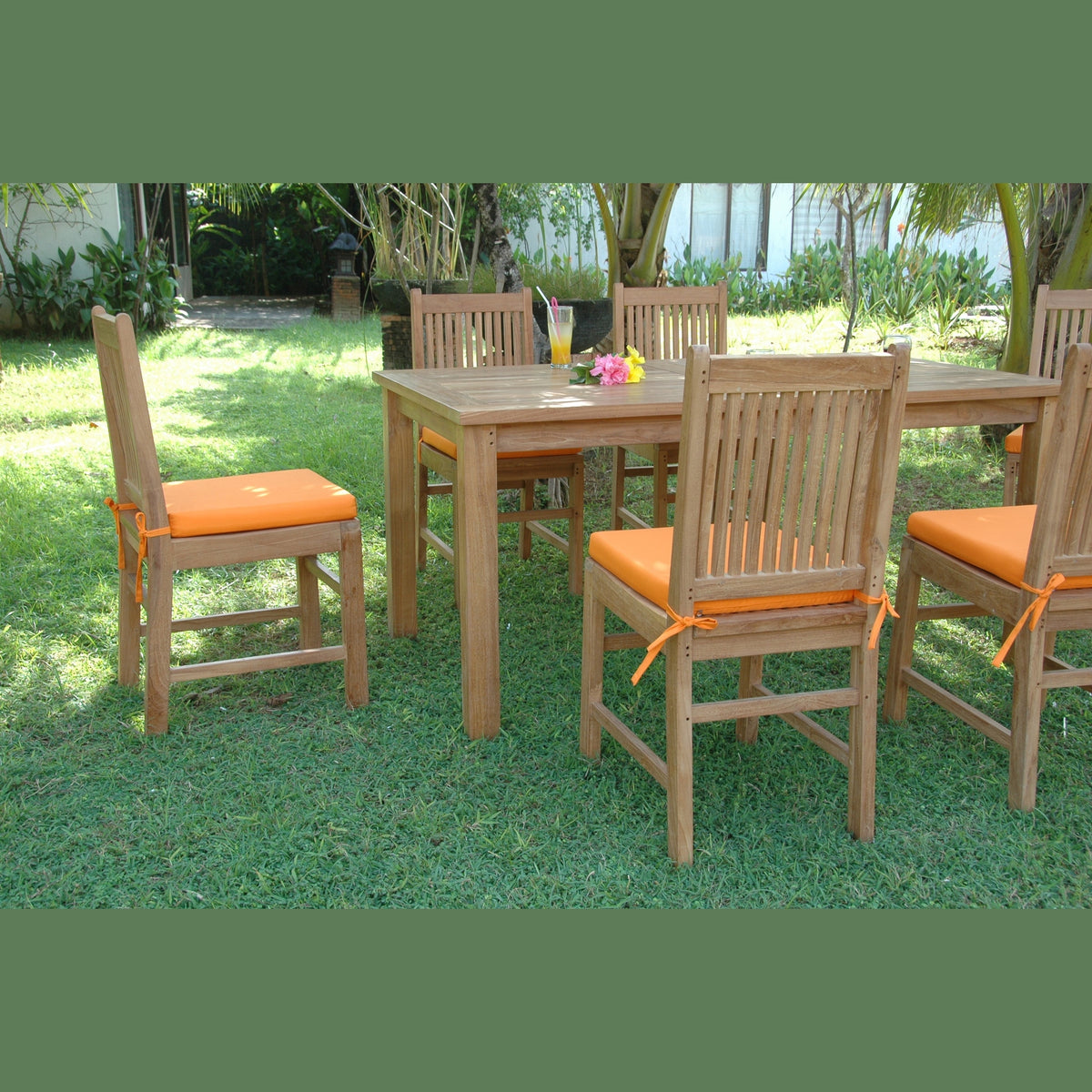 Outdoor dining set with wooden table and chairs on grass