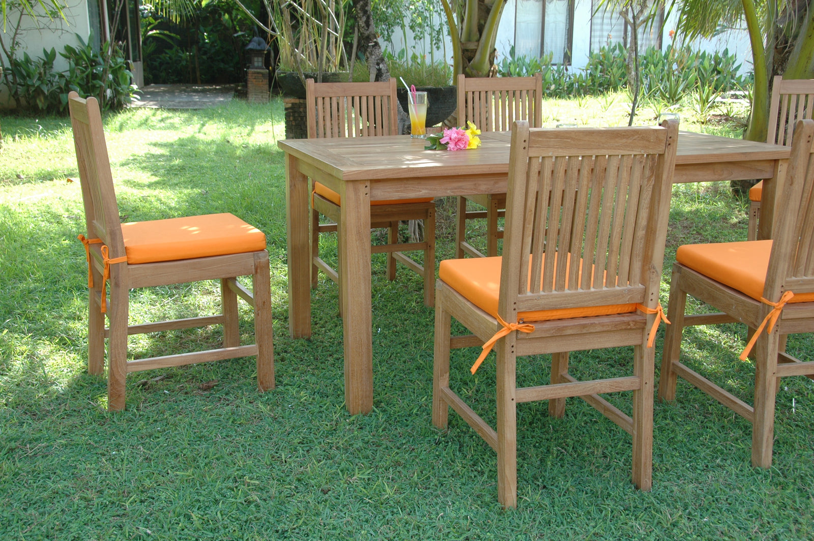 Outdoor dining set with wooden table and chairs on grass