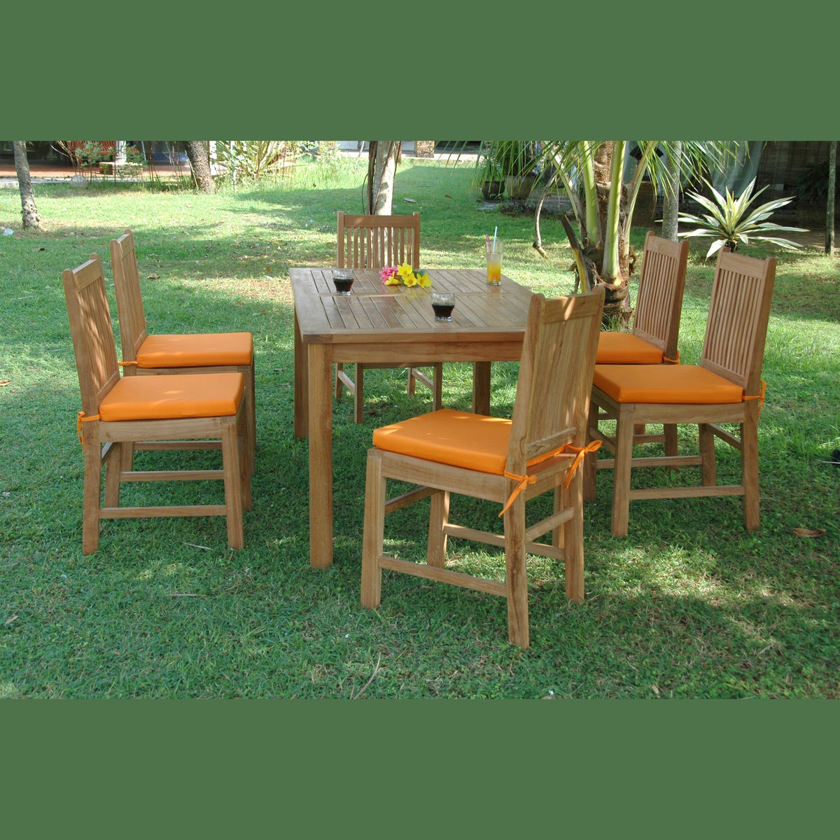 Outdoor dining set with wooden table and chairs on a grassy area