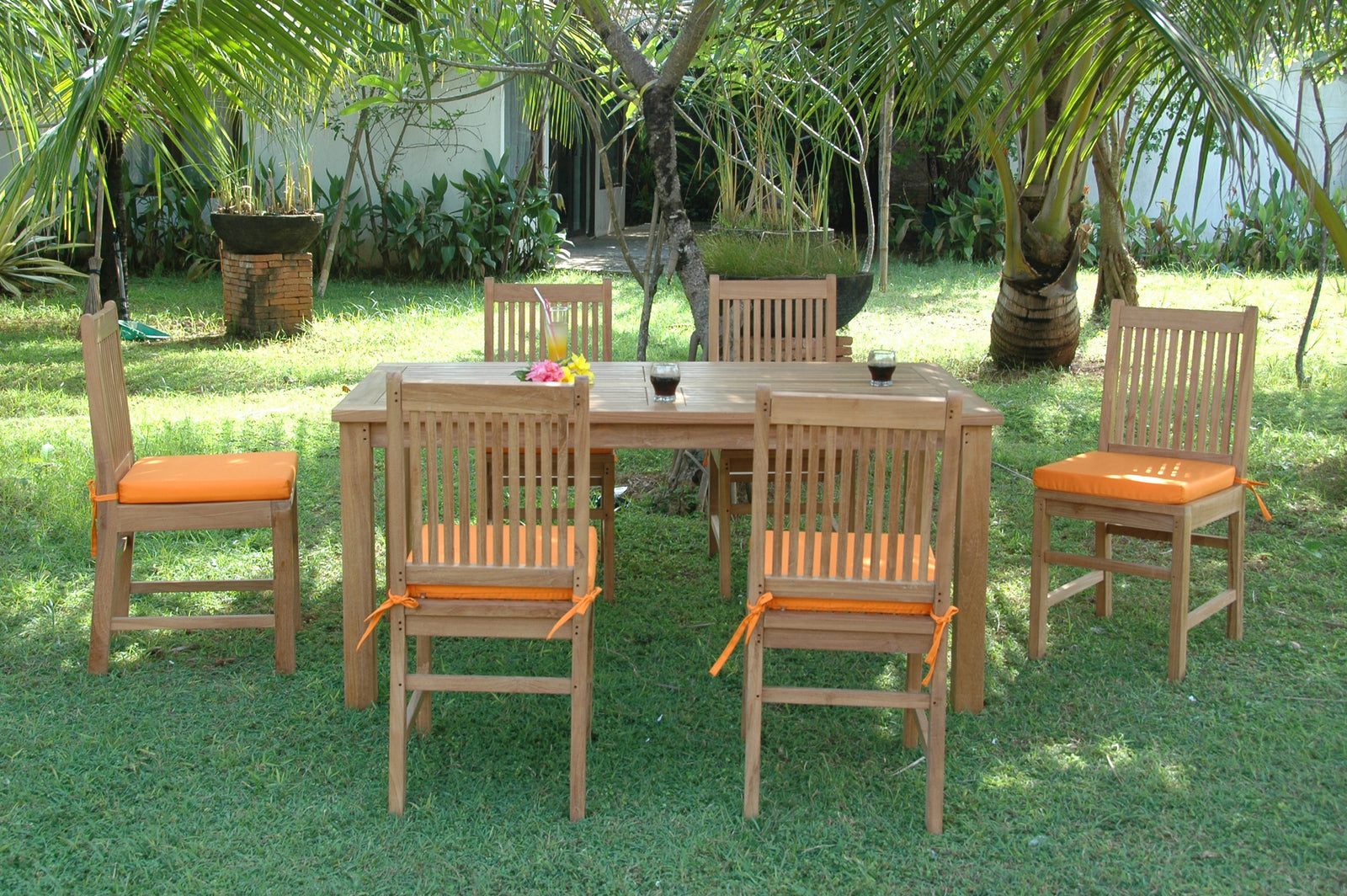 Outdoor dining set with wooden table and chairs on grass