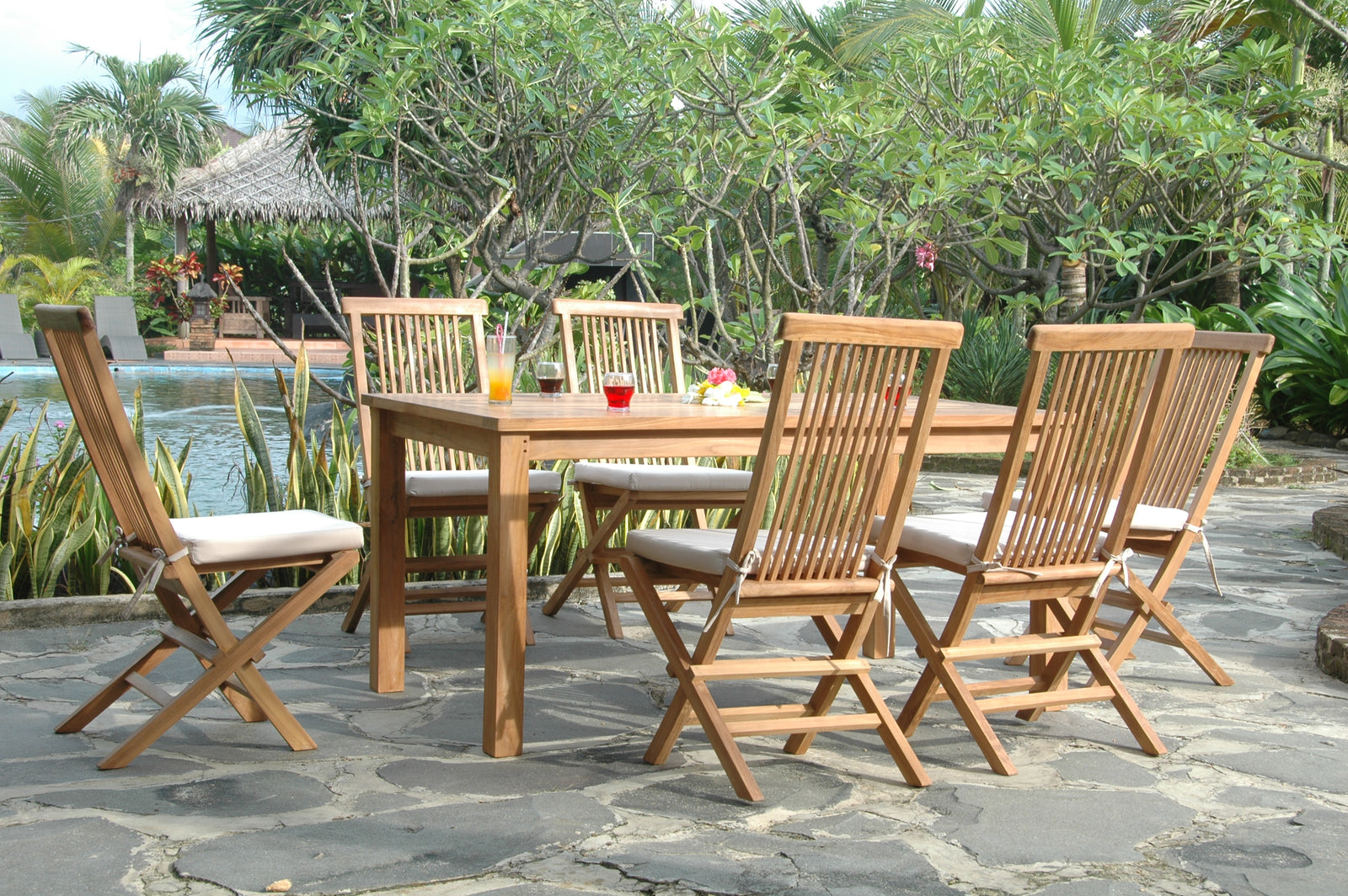Wooden outdoor dining set with chairs and table on a stone patio