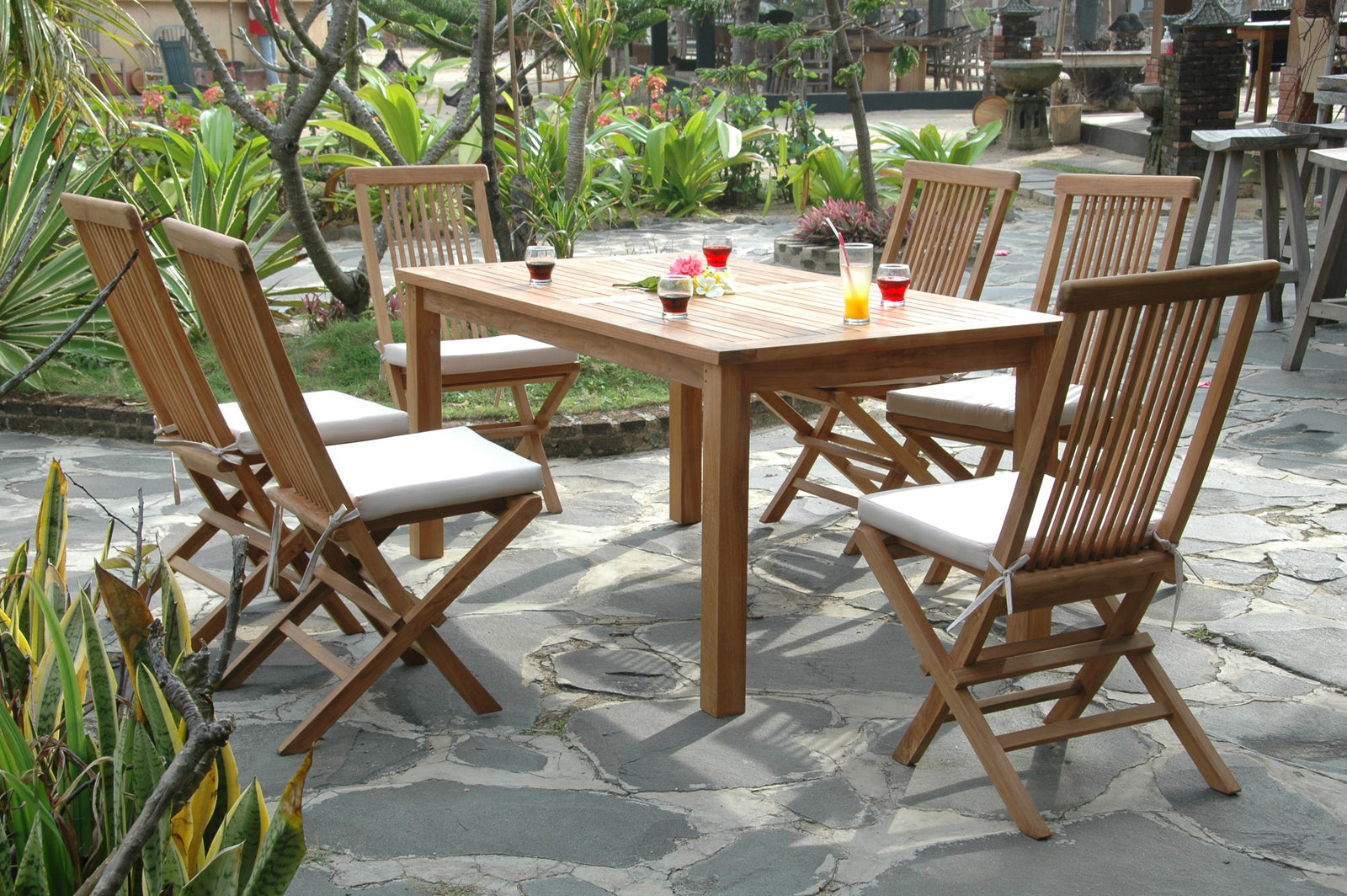 Wooden outdoor dining set with chairs and table on a stone patio