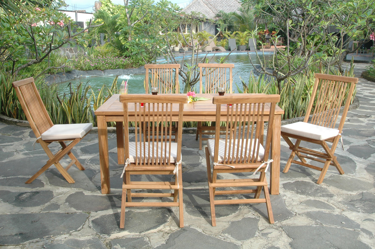 Wooden outdoor dining set with chairs on a stone patio near a pool.