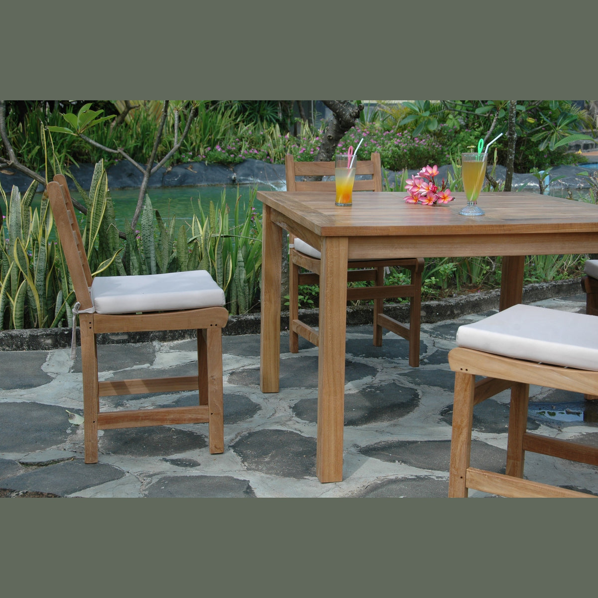 Wooden outdoor furniture set with drinks on a stone patio