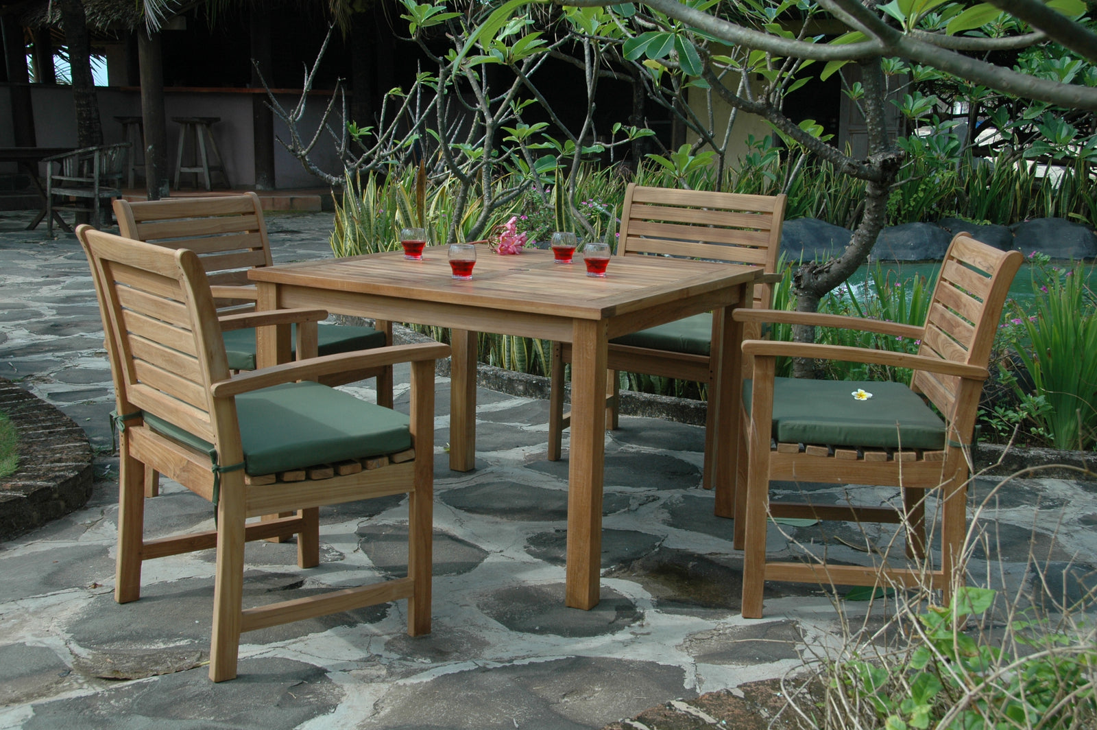 Wooden outdoor dining set with chairs and table on a stone patio