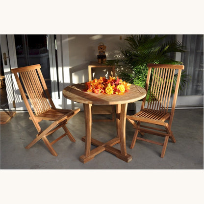 Wooden outdoor table with chairs and flowers on a patio