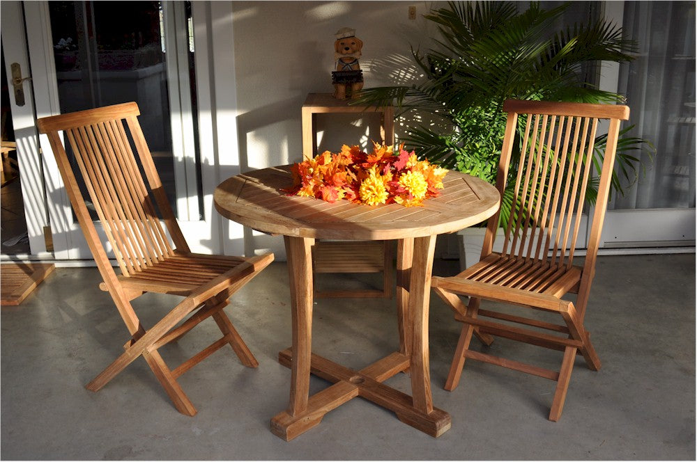 Wooden outdoor table with chairs and flowers on a patio