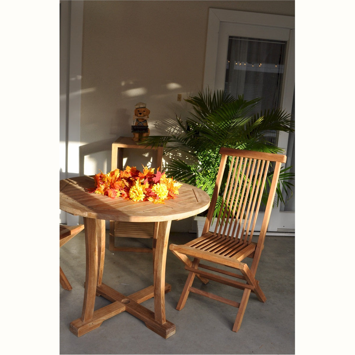 Wooden table with a chair and decorative flowers on a patio