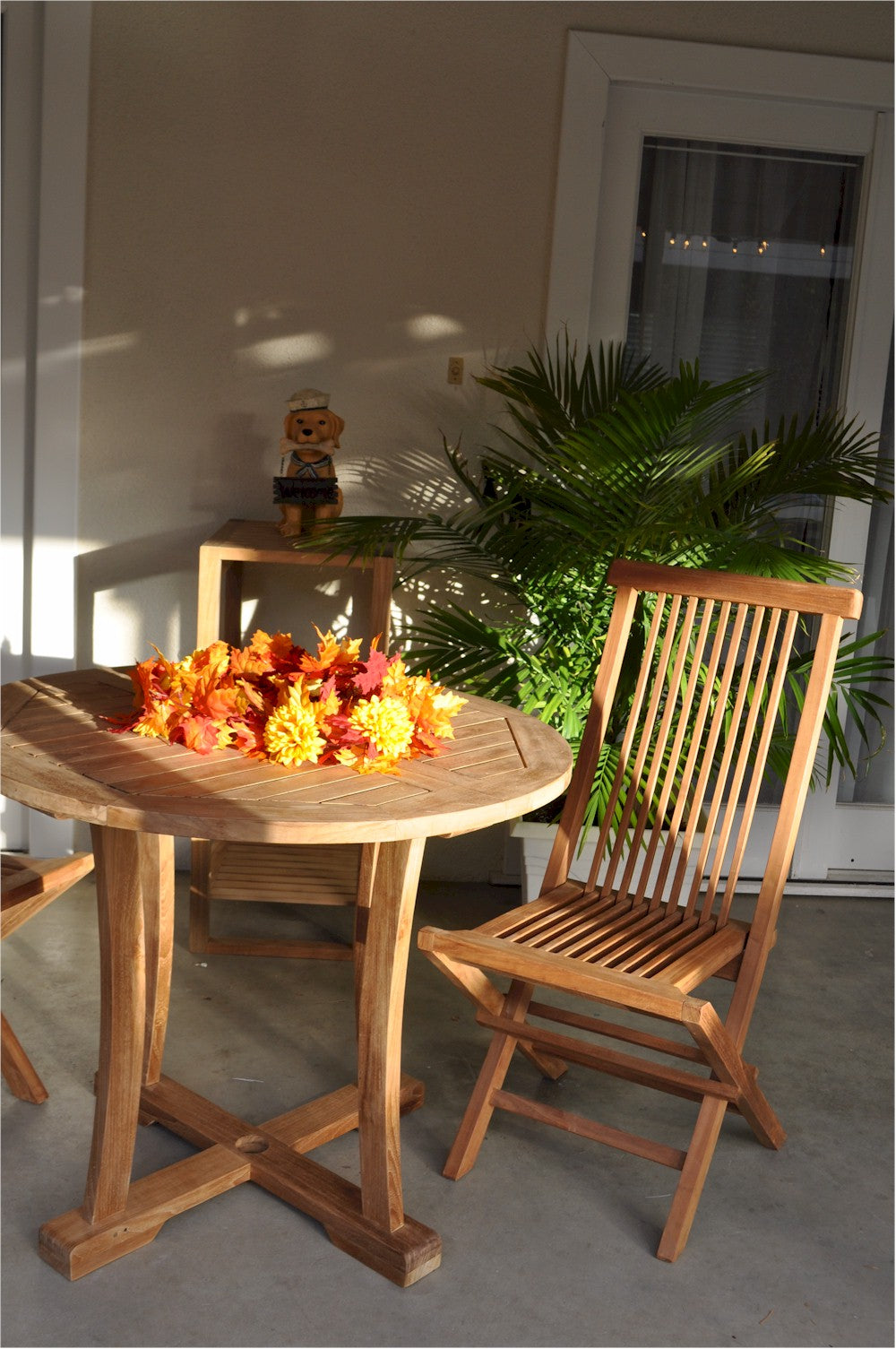 Wooden table with a chair and decorative flowers on a patio