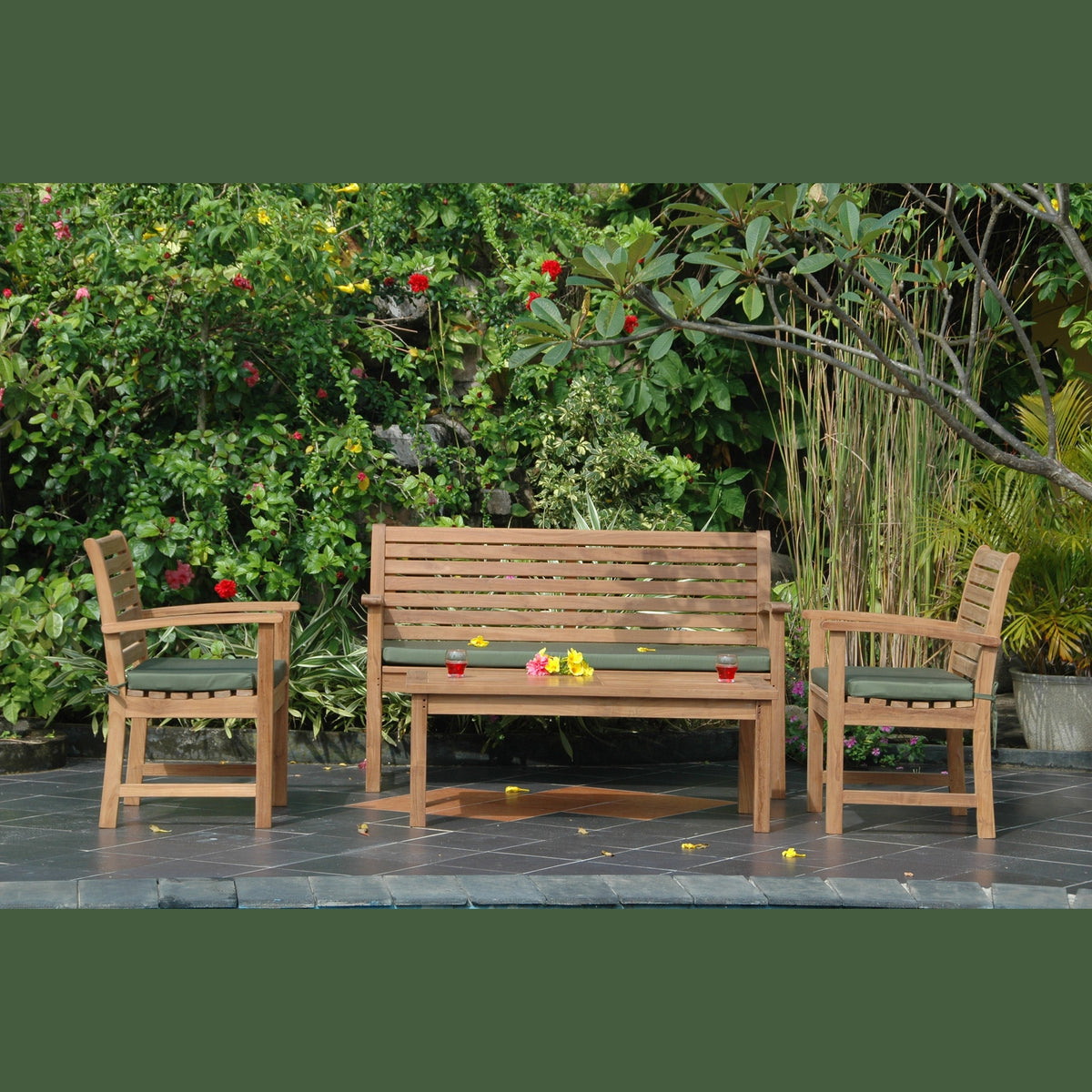 Wooden outdoor furniture set with bench and chairs on a patio, surrounded by greenery.