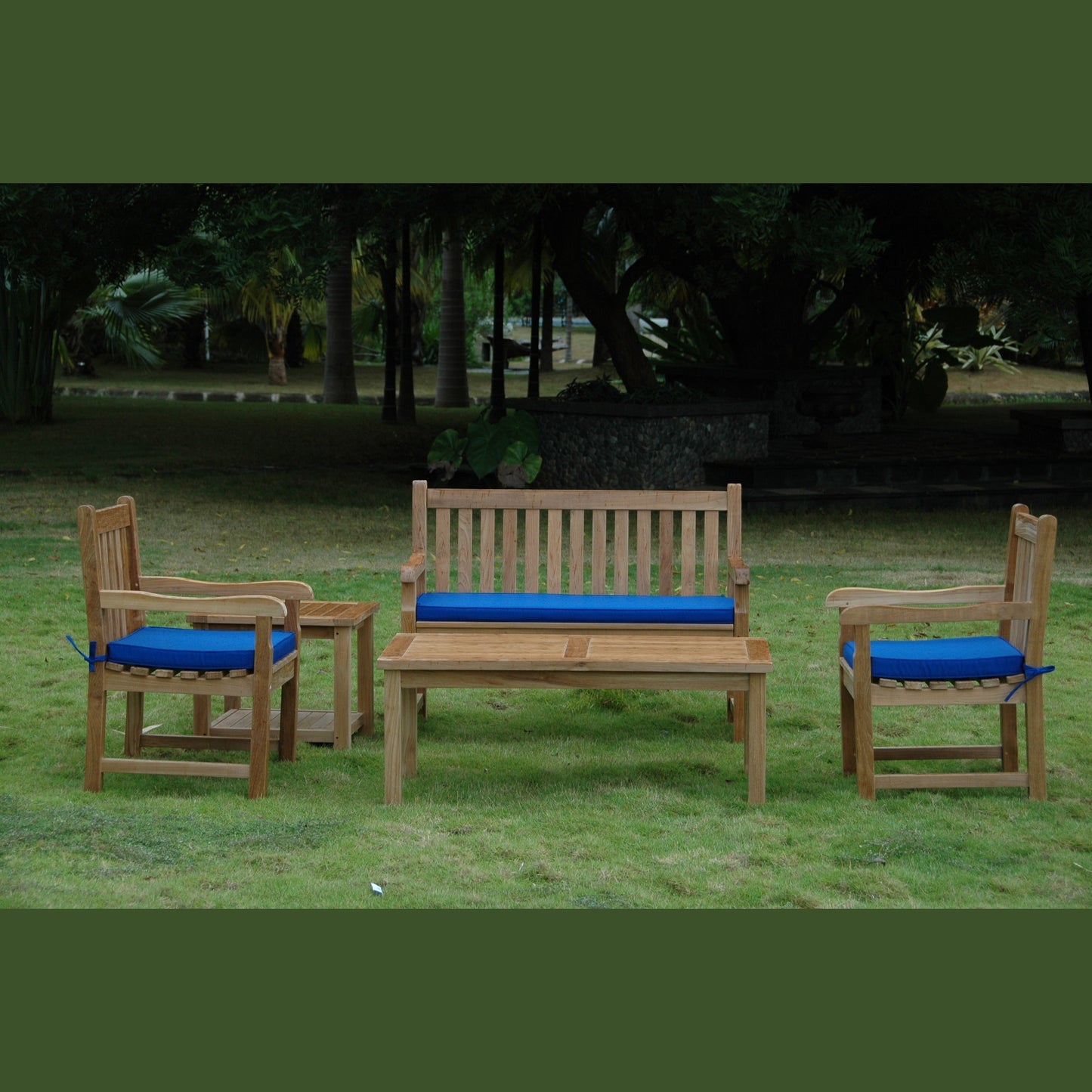 Wooden outdoor furniture set with blue cushions on a grassy area