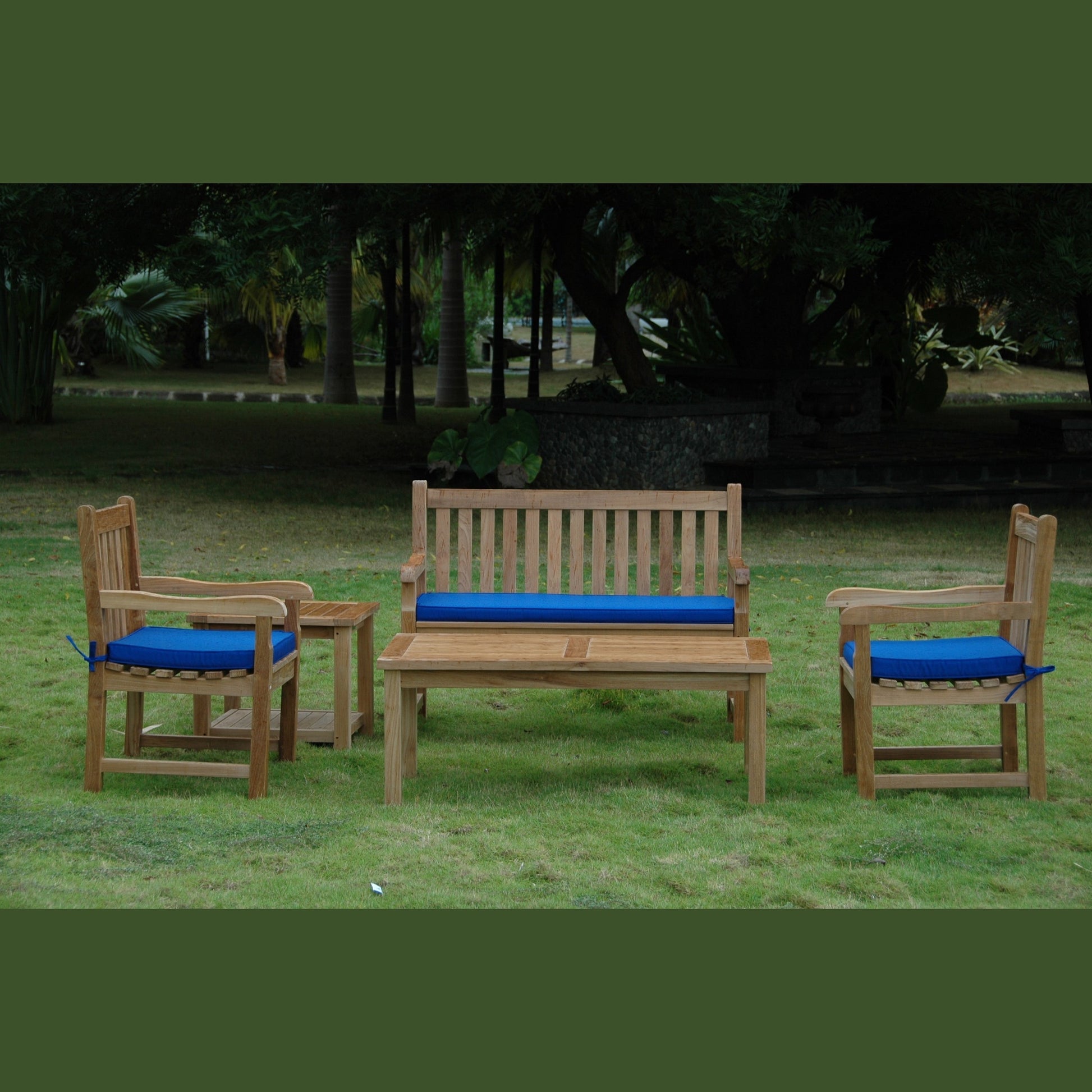 Wooden outdoor furniture set with blue cushions on a grassy area