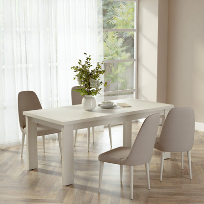 Dining room with a white table and chairs near a window with white curtains.