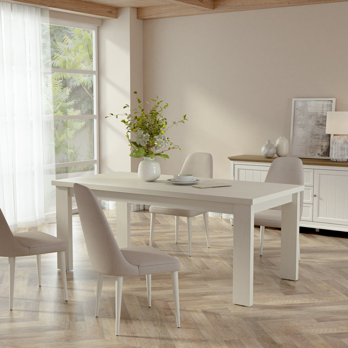 Dining room with a white table and chairs in a bright room with large windows.