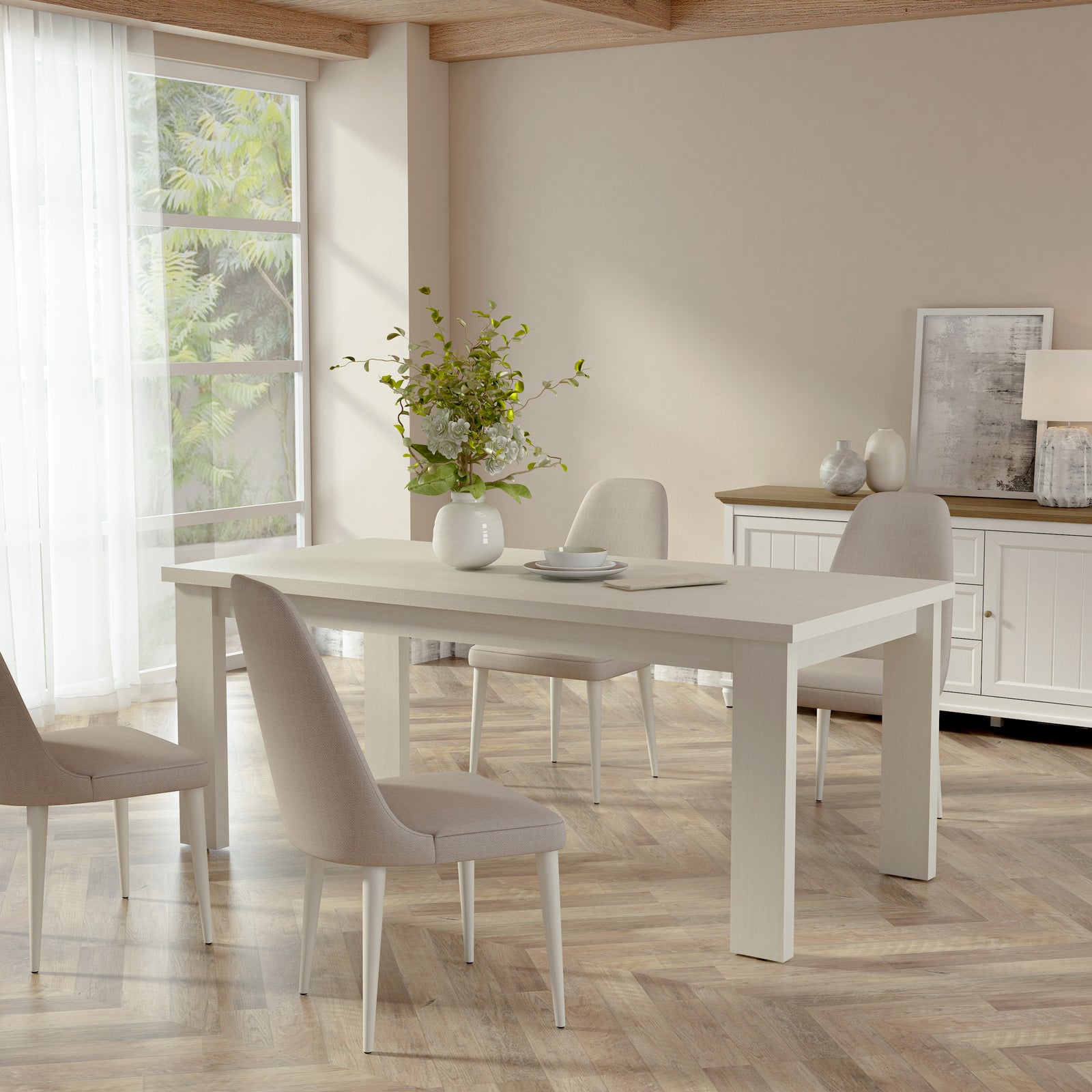 Dining room with a white table and chairs in a bright room with large windows.
