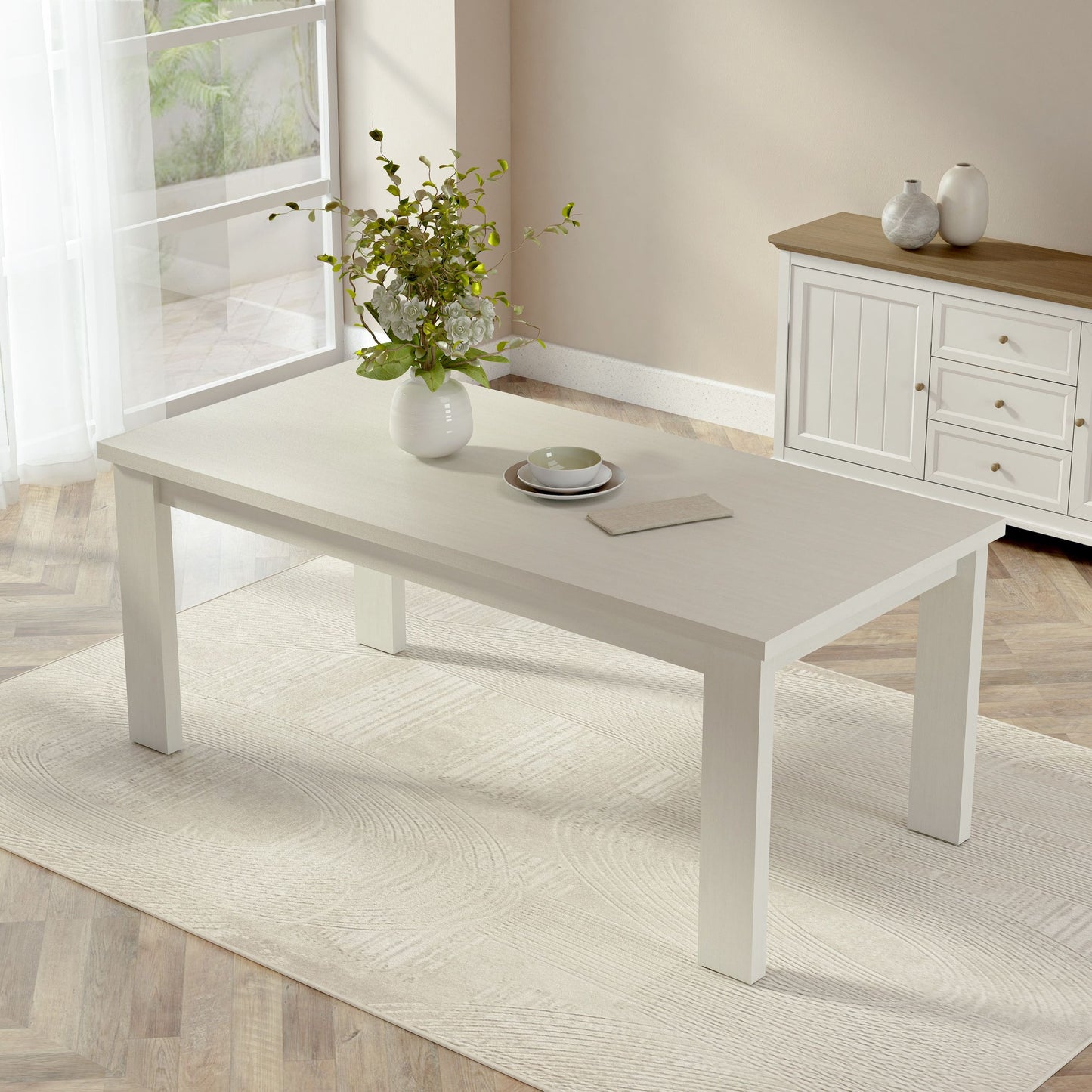 White coffee table with decorative items in a room with a rug and cabinet.