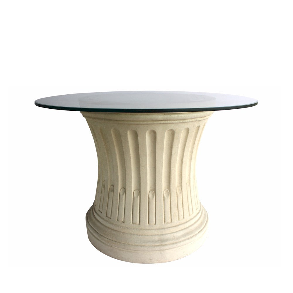 Round table with glass top and decorative beige base on a white background
