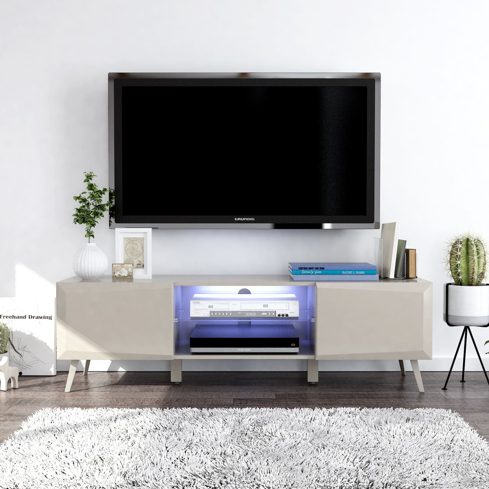 Modern TV stand with a television mounted on a white wall, featuring decorative items.