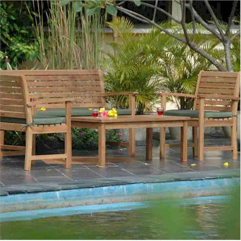 Wooden outdoor furniture set with green cushions by a poolside.