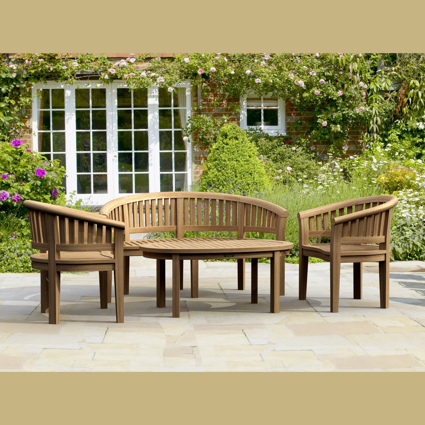Wooden outdoor furniture set with a bench and chairs on a patio, surrounded by greenery.