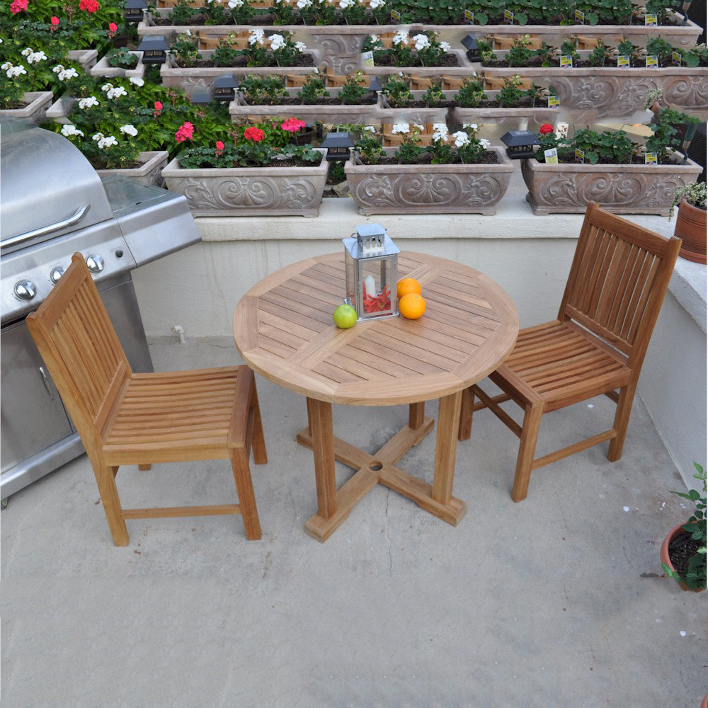 Wooden outdoor table with chairs on a patio with potted plants in the background