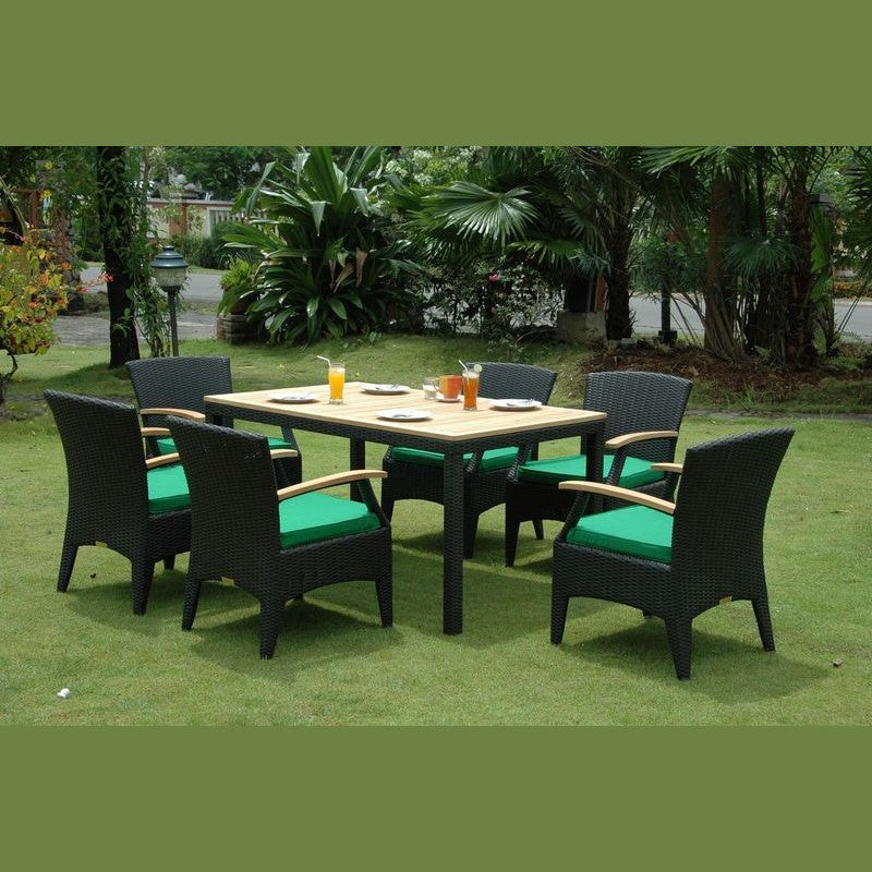 Outdoor dining set with a table and chairs on a grassy area with greenery.