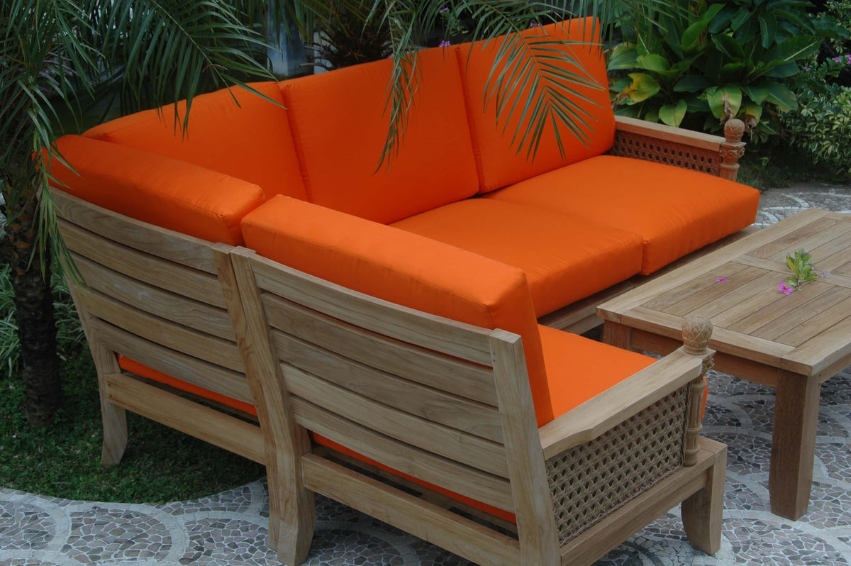 Outdoor furniture set with orange cushions and wooden frame in a garden setting.