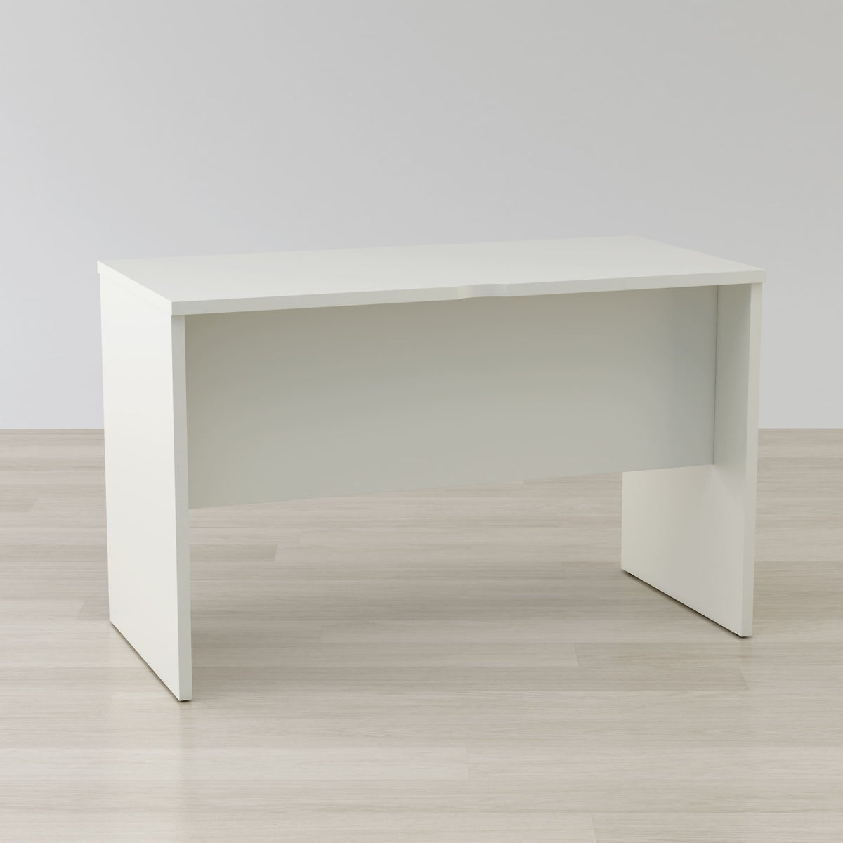 White desk on a light wooden floor with a plain white wall background
