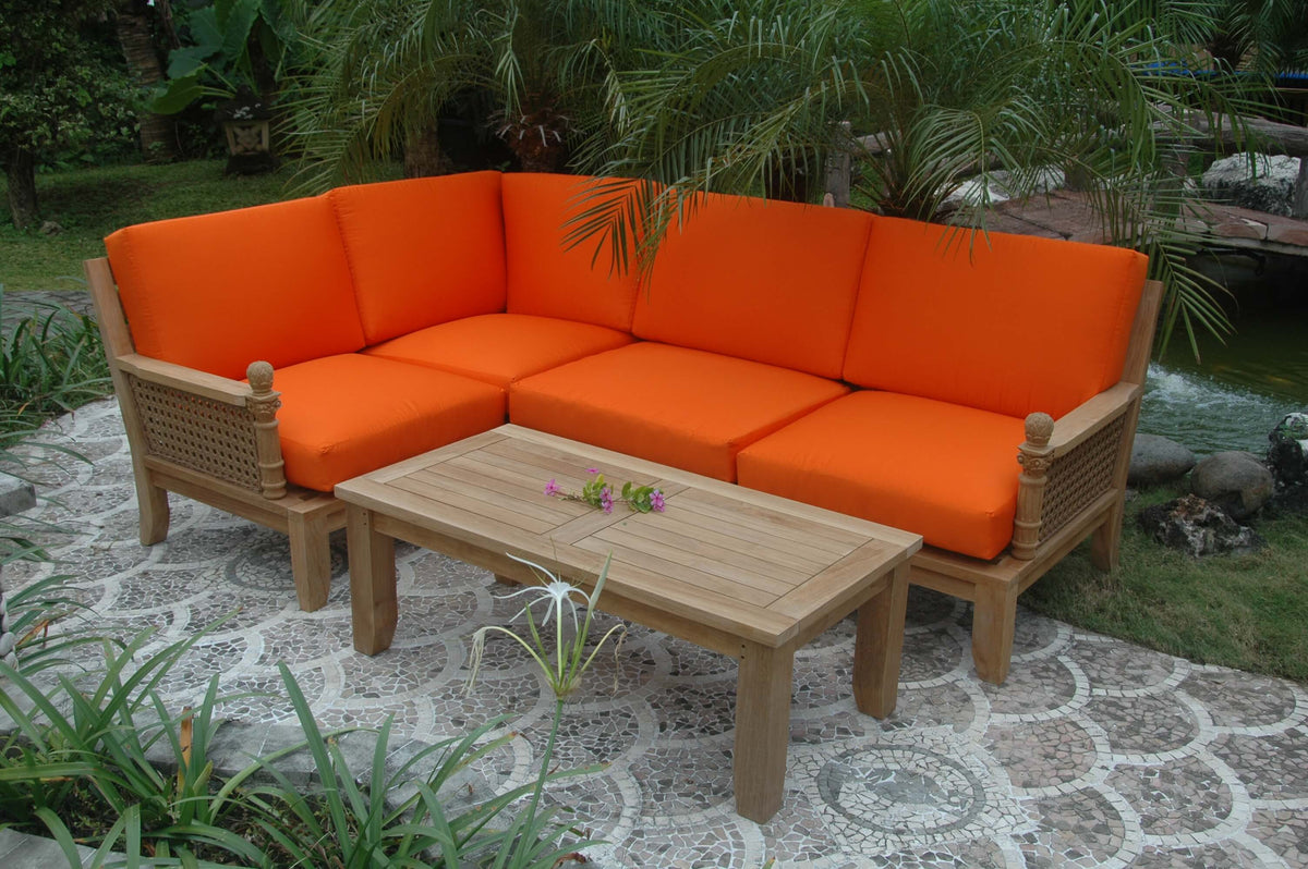 Outdoor patio set with orange cushions and a wooden table in a garden setting.