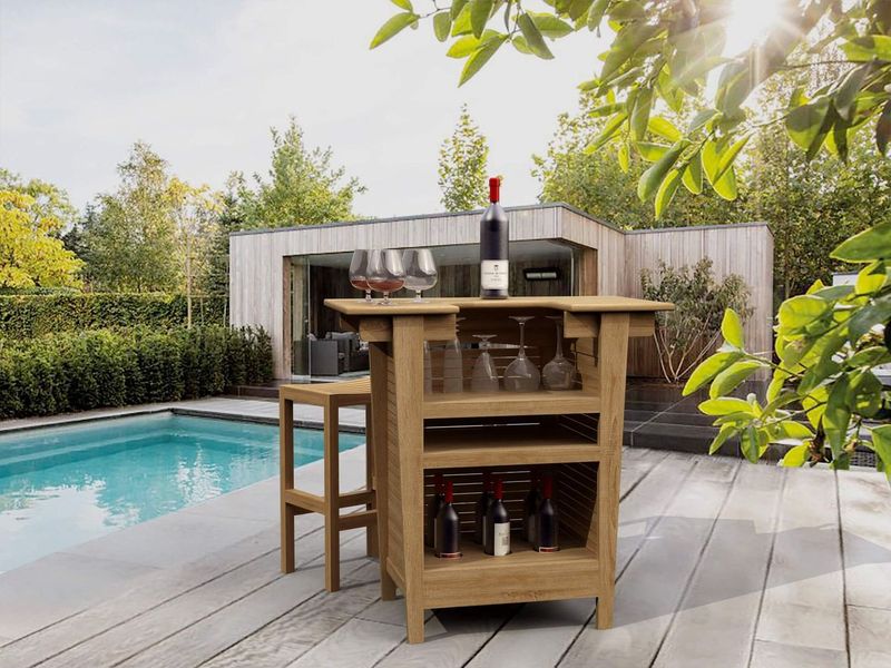 Outdoor kitchen island with bottles and glasses by a poolside