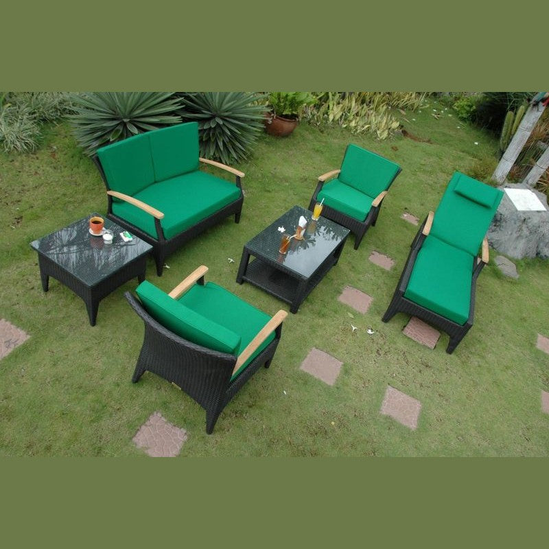 Outdoor furniture set with green cushions on a grassy area