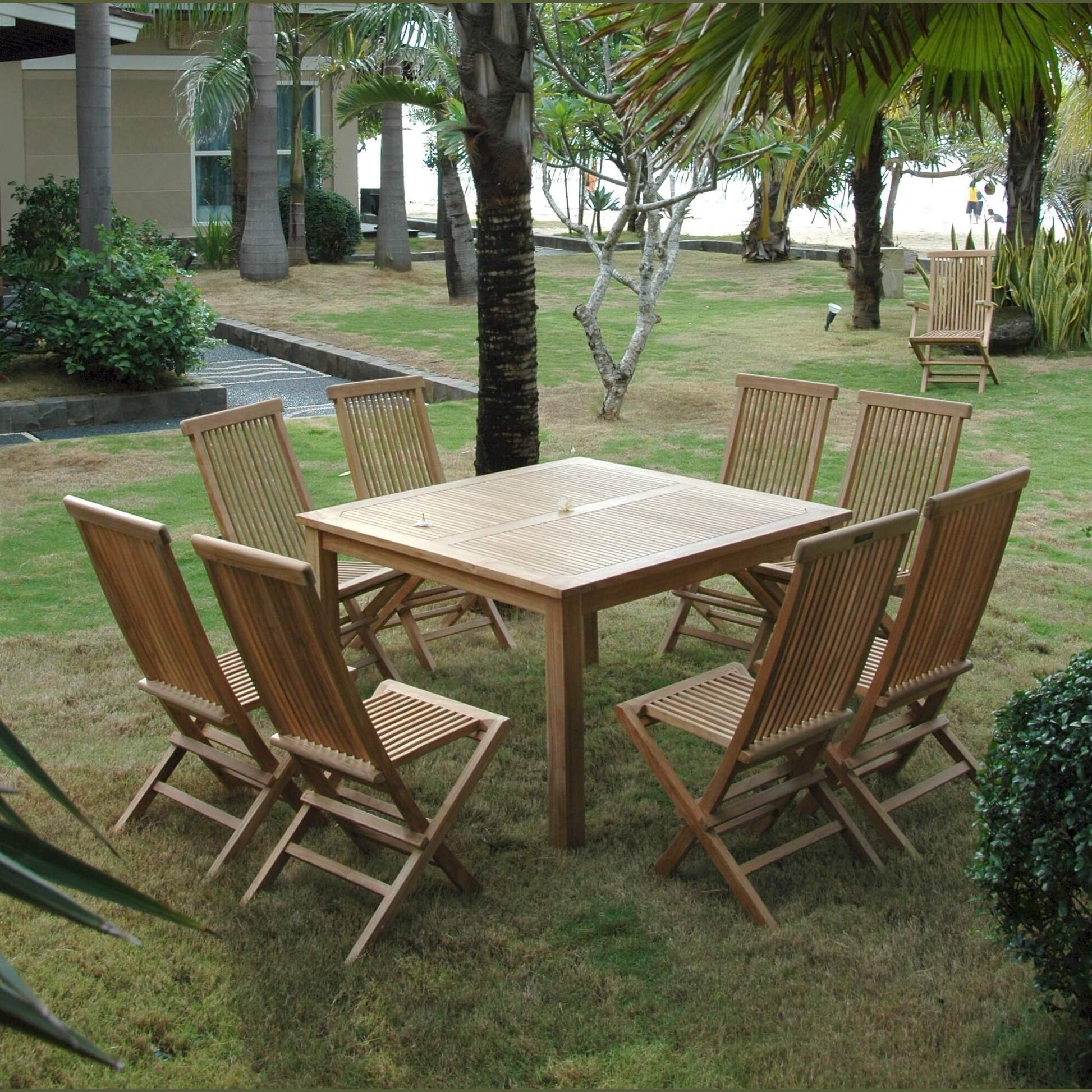 Wooden outdoor dining table with chairs in a garden setting