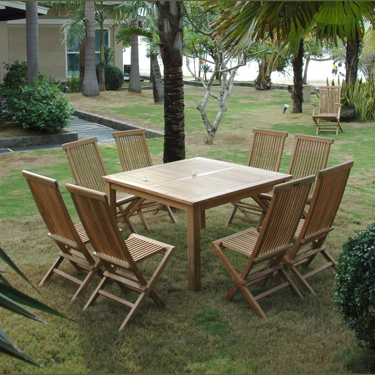Wooden outdoor dining table with chairs in a garden setting