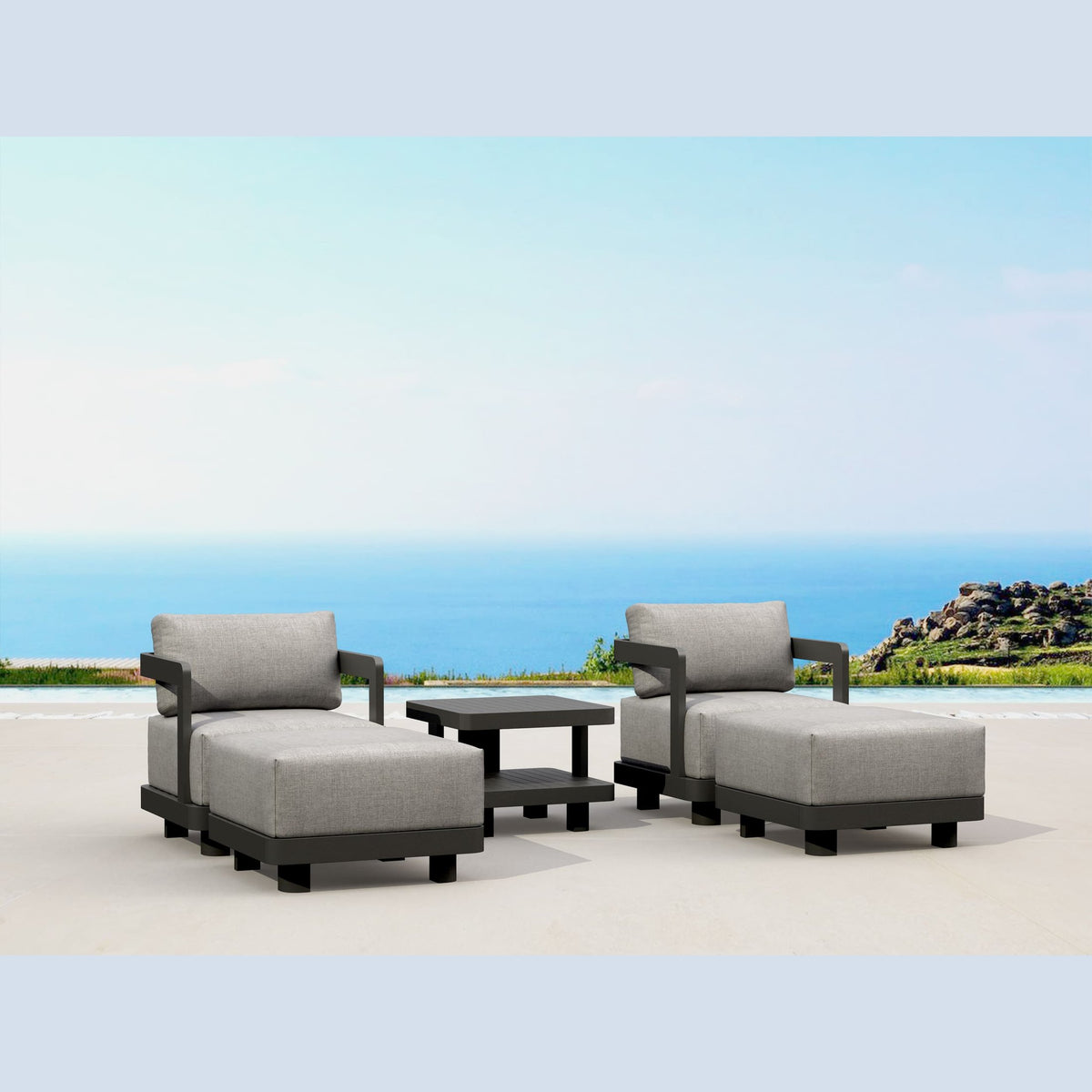 Outdoor patio furniture set with gray cushions and a small table on a sandy beach.