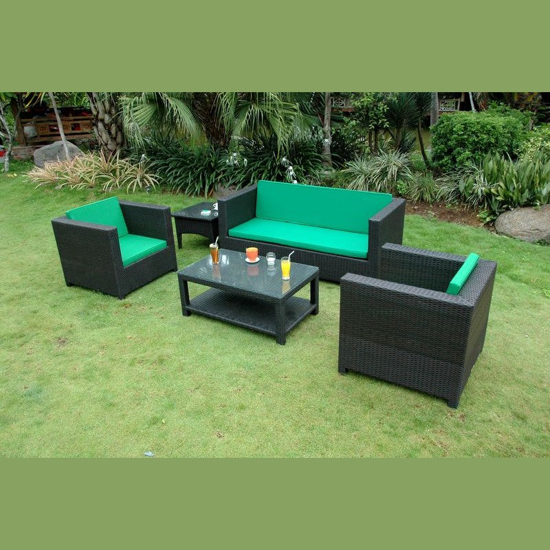 Outdoor furniture set with green cushions on a grassy area