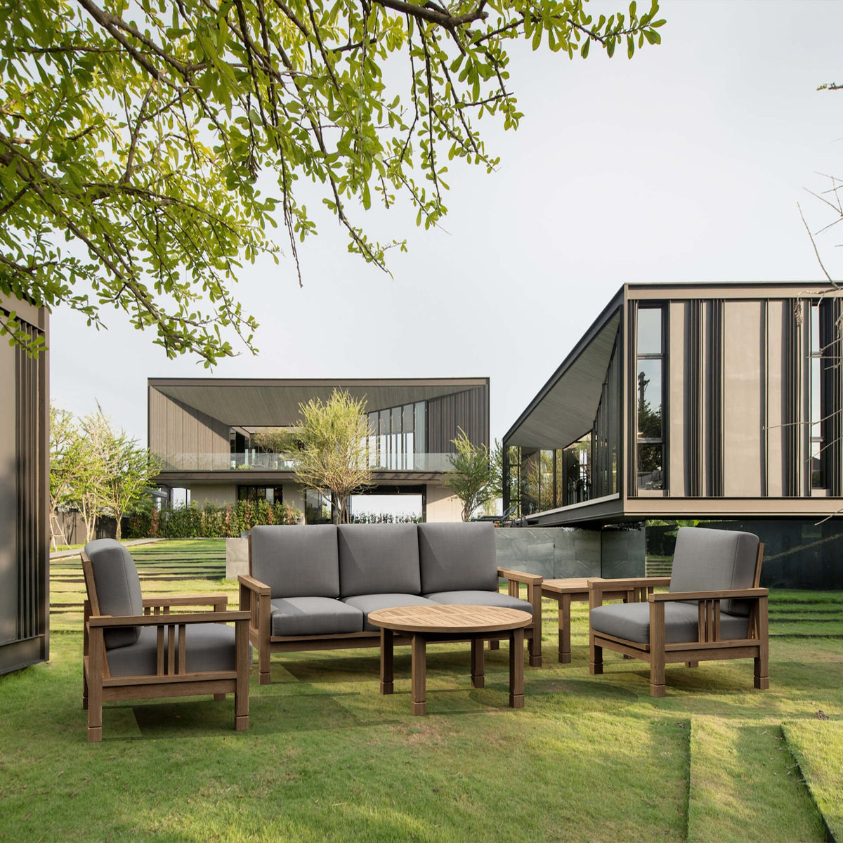 Outdoor furniture set on a grassy area with modern house in the background