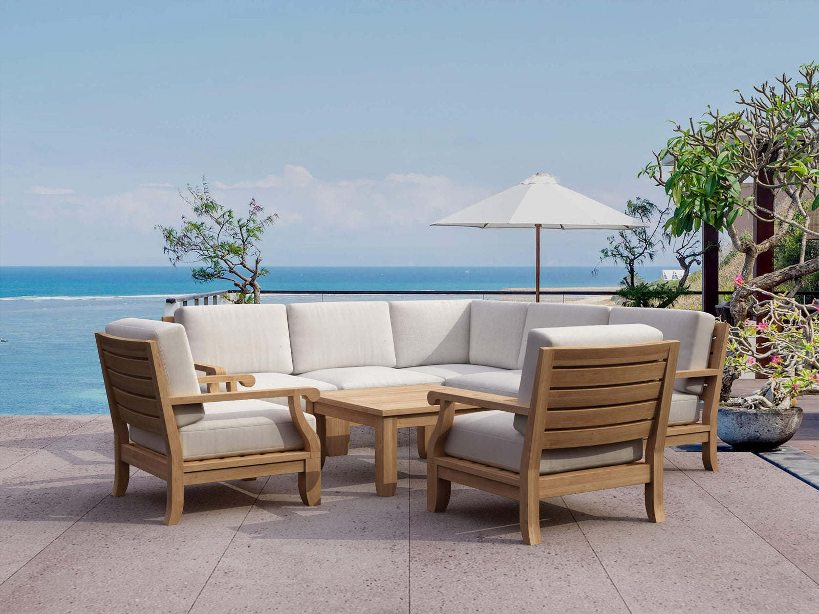 Outdoor furniture set with beige cushions and wooden frames on a patio overlooking the ocean.