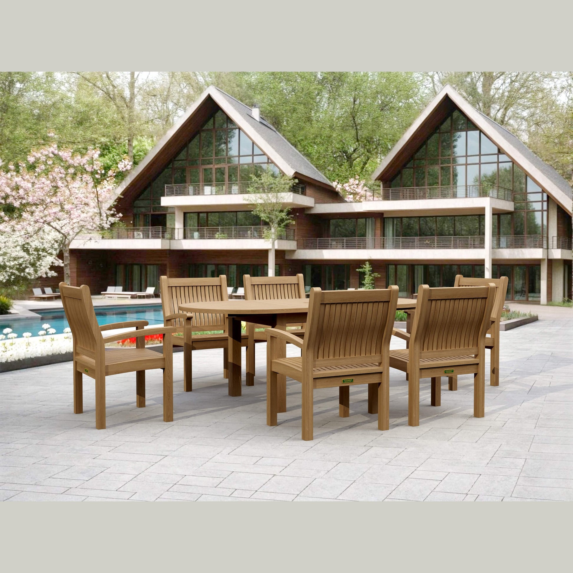 Wooden outdoor dining set in front of a modern house with a pool.