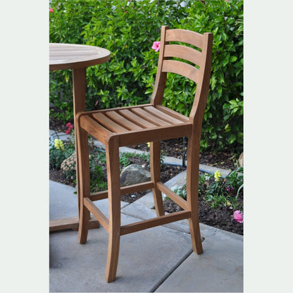 Wooden bar stool on a patio with a garden background