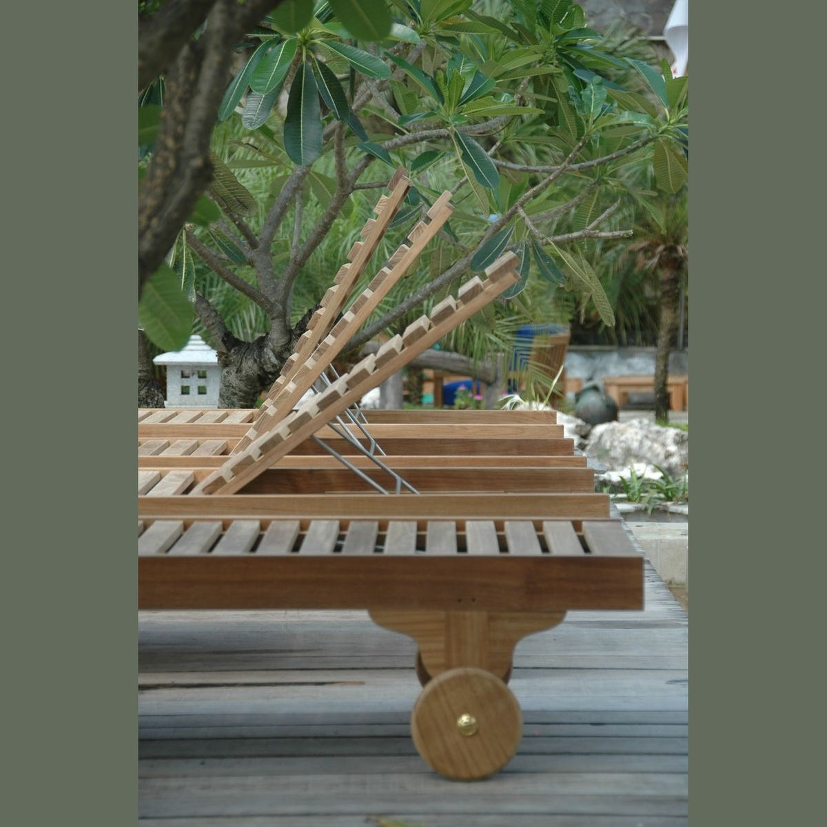 Wooden lounge chair on wheels in a garden setting