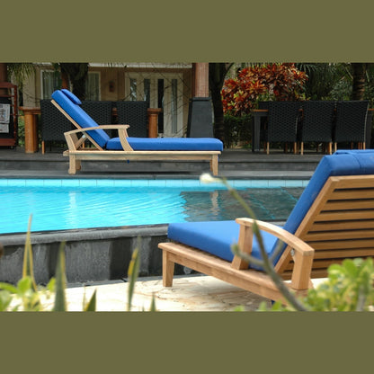 Blue lounge chairs by a pool with a tropical setting