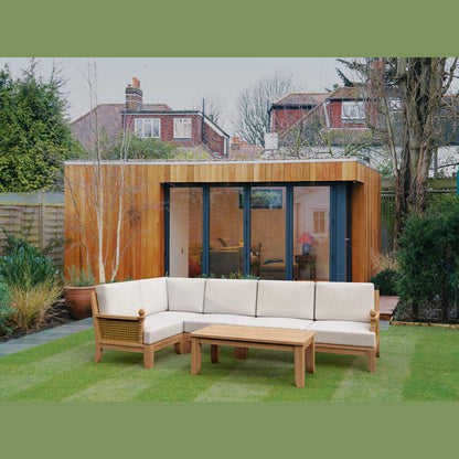 Outdoor living space with a wooden sectional sofa and coffee table in a garden setting.