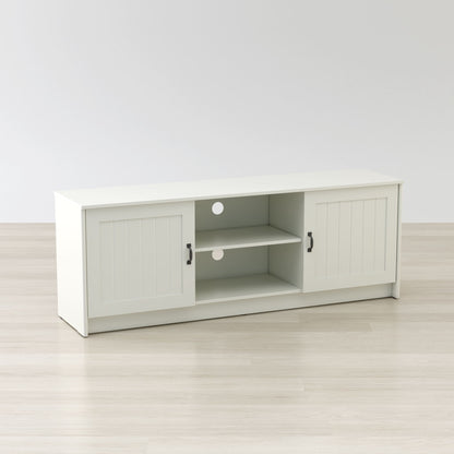 White TV stand with sliding doors on a light wooden floor and white wall background