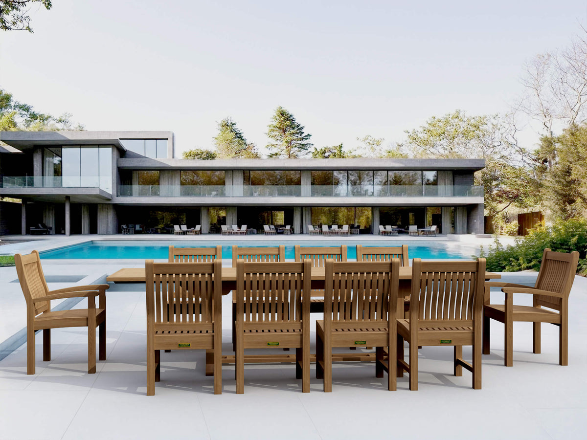 Wooden outdoor dining set with chairs near a modern house and pool.