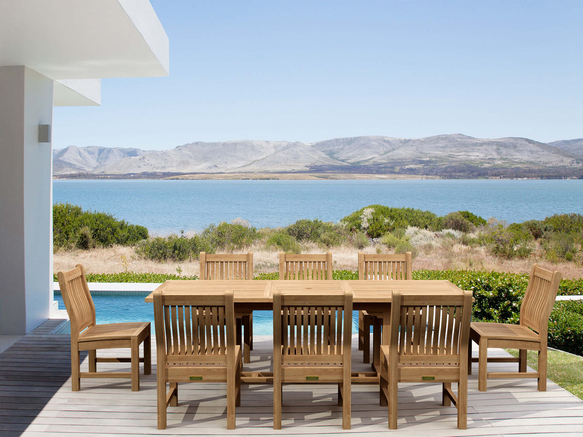 Wooden outdoor dining set with chairs on a deck overlooking a scenic view of water and mountains.