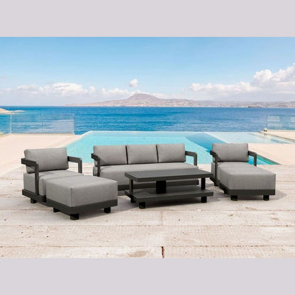 Outdoor patio furniture set with gray cushions by a pool and ocean view.