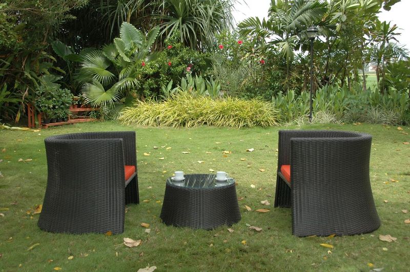 Black outdoor furniture set on a grassy area with greenery in the background